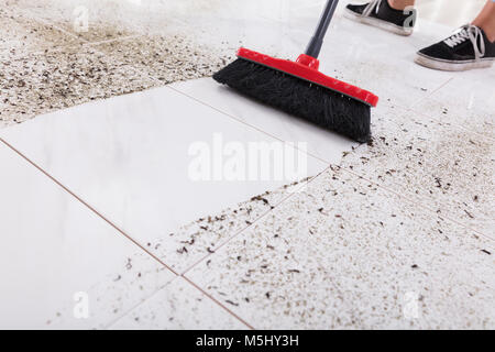 Balai de nettoyage de salissures sur le carrelage à la maison Banque D'Images