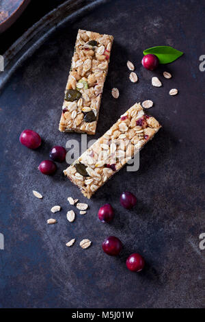 Deux barres muesli avec des canneberges sur fond sombre Banque D'Images