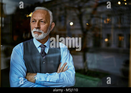 Elegant man looking out of window Banque D'Images