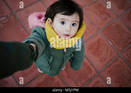 Portrait of little girl holding mother's hand looking up Banque D'Images