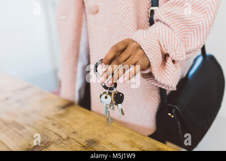 Femme à la maison, mettant les clés sur le tableau Banque D'Images