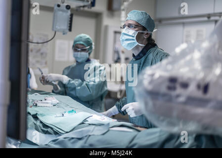 Neuroradiologist dans scrubs pendant le fonctionnement à la recherche à surveiller Banque D'Images