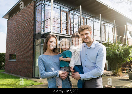 Portrait of smiling family devant leur maison Banque D'Images