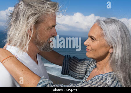 Romantic couple dans chaque autres des yeux en face de la mer Banque D'Images