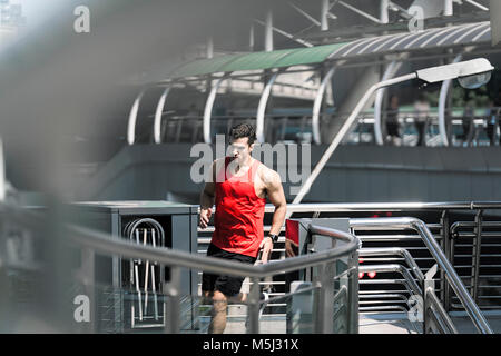 Runner Fitness shirt rouge en tournant sur le pont moderne Banque D'Images