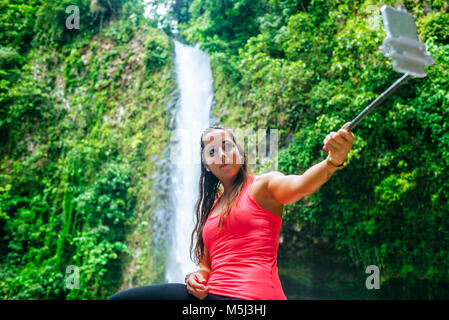 Costa Rica, Arenal Volcano National Park, prendre une femme avec la cascade de selfies La Fortuna Banque D'Images