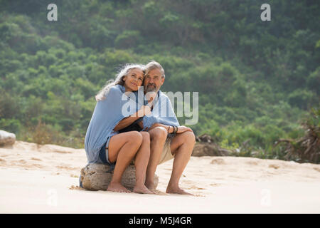 Couple sur la plage, enveloppé dans une couverture Banque D'Images