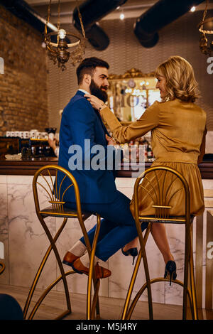 Couple élégant assis au comptoir dans un bar Banque D'Images