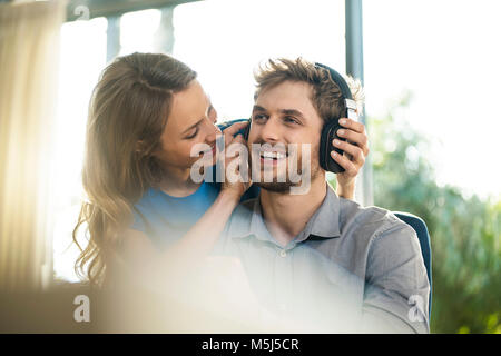 Femme de mettre le casque sur l'ami Banque D'Images