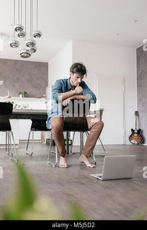 Young man using laptop in a loft Banque D'Images