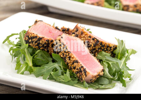 Tataki de thon en croûte de sésame sur fond bois plaque apéritif Banque D'Images