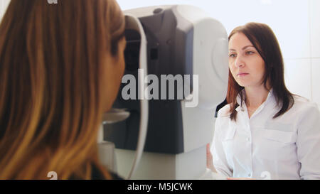 Clinique d'Ophtalmologie - optométriste vérifie la vision du patient par machine électronique moderne Banque D'Images