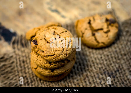 Fraîchement fait maison biscuits aux brisures de chocolat sur fond de jute. Banque D'Images
