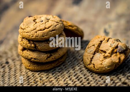 Fraîchement fait maison biscuits aux brisures de chocolat sur fond de jute. Banque D'Images