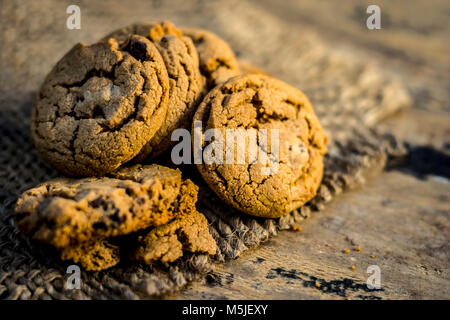Fraîchement fait maison biscuits aux brisures de chocolat sur fond de jute. Banque D'Images