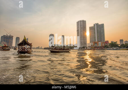 BANGKOK, THAÏLANDE, Mars 02, 2017 - La rivière Chao Praya, à Bangkok, les bâtiments et bateaux au coucher du soleil Banque D'Images