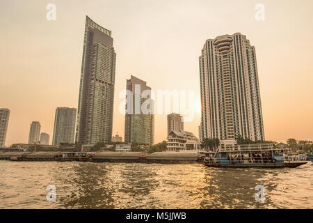 BANGKOK, THAÏLANDE, Mars 02, 2017 - La rivière Chao Praya, à Bangkok, les bâtiments et bateaux au coucher du soleil Banque D'Images