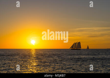 USA, Floride, ciel coucher de soleil orange intense sur deux voiliers silencieux sur l'océan Banque D'Images