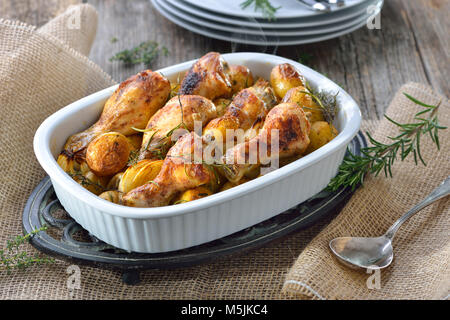 Frais du four : pilons de poulet au four avec des petites pommes de terre et oignons Banque D'Images