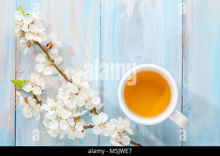 Tasse de thé et de la direction générale de l'épanouissement sur abricot vieille table en bois. Banque D'Images