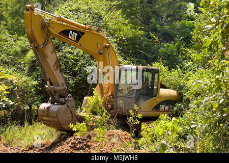 Cat 3200 trackhoe (voie hoe, pelle, Pelle mécanique) de creuser un fossé de drainage le long d'un chemin d'exploitation de gravier dans la rivière Alabama Swamp, dans Clack Banque D'Images