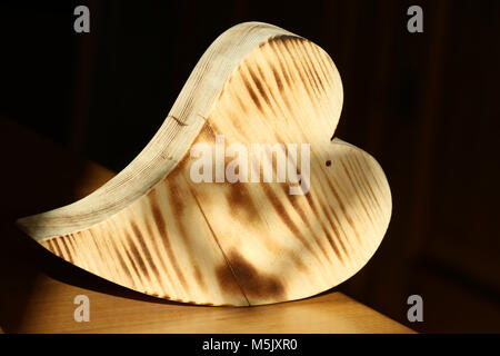 Coeur bois ondé sur tableau avec fond sombre Banque D'Images