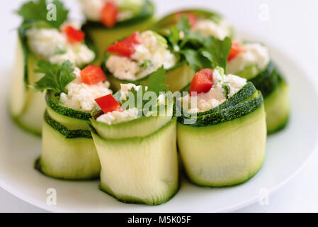 Rouleaux de courgettes farcies au fromage et ciboulette et paprika rouge. Banque D'Images