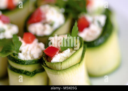 Rouleaux de courgettes farcies au fromage et ciboulette et paprika rouge. Banque D'Images