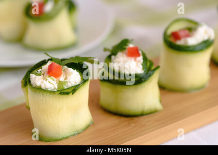 Rouleaux de courgettes farcies au fromage et ciboulette et paprika rouge. Banque D'Images