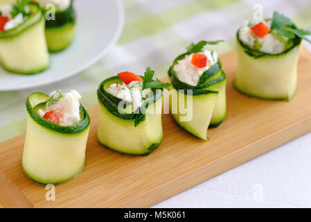 Rouleaux de courgettes farcies au fromage et ciboulette et paprika rouge. Banque D'Images