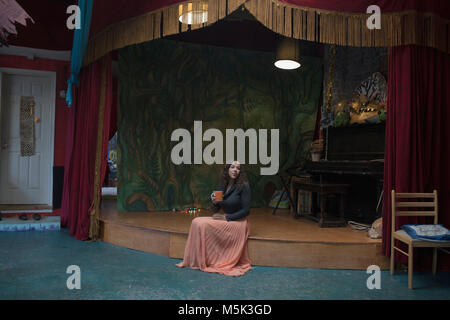 Jeune femme peintre assis sur une scène Banque D'Images