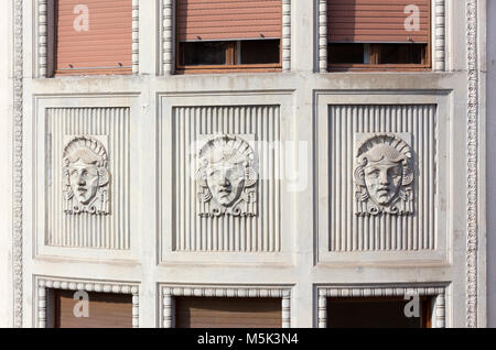 Des sculptures de marbre Art Nouveau d'un visage sur une façade de bâtiment à Trieste, Italie Banque D'Images