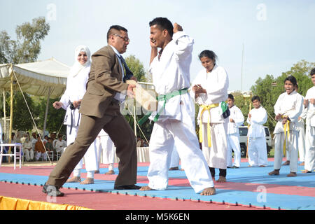 Hyderabad, Pakistan. Feb 23, 2018. Un instructeur a frappé azeh sur un estomac pour hommes au cours de la présentation du Kyokushin Karaté pendant le championnat national Credit : Janali Laghari/Pacific Press/Alamy Live News Banque D'Images