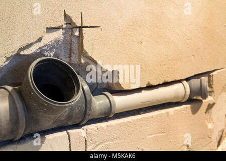 L'installation des tuyaux d'égout dans la salle de bains d'un appartement intérieur au cours de travaux de rénovation. Tuyau de vidange en plastique gris utilisé pour l'eau. Banque D'Images