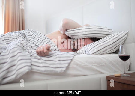 Homme mature ivre de dormir dans son lit Banque D'Images