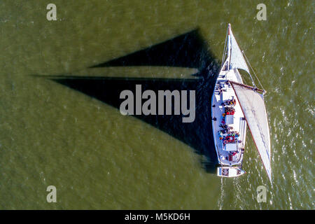 Le soleil jette de l'ombre dramatique de la voile traditionnelle de la bonite bateau naviguant sur la baie de Chesapeake, traiter, l'Île de France. Banque D'Images