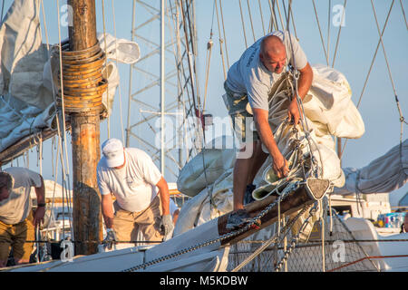 Les mâles adultes se préparer à être hissé sur voiles Listao traditionnels de l'île en bateau, les traiter, au Maryland. Banque D'Images