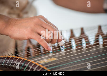 Détail de femme plumant des chaînes de l'instrument au riche passé du guzheng, Greensboro, Caroline du Nord. Banque D'Images