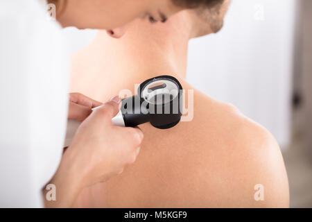 Close-up of a female Doctor Examining Patient Dermatoscope avec peau de Banque D'Images
