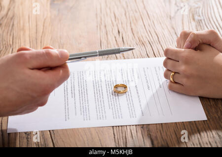 Close-up of Woman Singing entente de divorce avec bague de mariage d'or sur papier Banque D'Images