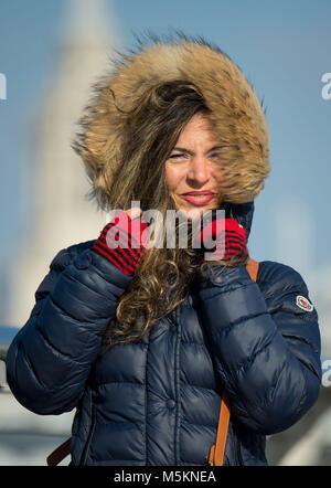 Une femme marche à travers le pont du Millenium, dans le centre de Londres, en présence de vent, que le gel de l'air La Russie est à serrer le UK dans ce qui est défini pour être le plus froid de la fin de février à cinq ans. Banque D'Images