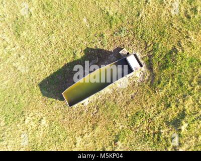 Vue aérienne au-dessus d'une cuve d'eau du bétail dans un champ agricole. Banque D'Images