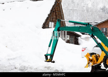 Le chargeur pour neige supprime neige sur la route dans le village Banque D'Images