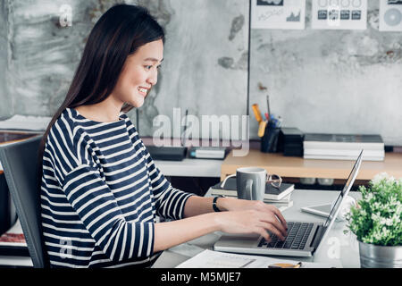 Asian businesswoman typing travaillant sur ordinateur portable et à la recherche à l'écran,Office bureau concept de vie Banque D'Images