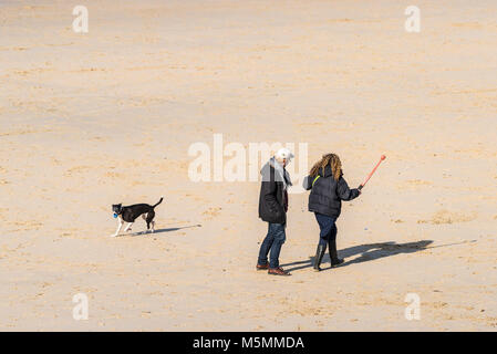 Les promeneurs de chiens sur la plage de Sennen Cove à Cornwall Banque D'Images