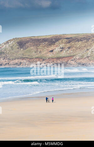 Les promeneurs de chiens sur la plage de Sennen Cove à Cornwall. Banque D'Images