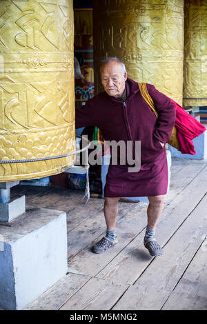 Thimphu, Bhoutan. Vieil Homme tournant des moulins à prière au National Memorial chorten. Banque D'Images