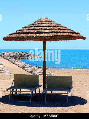 Plage avec parasols réalisés avec le bambou et la paille dans le resort Banque D'Images