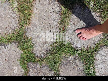 Homme marchant pieds nus sur les pierres de la voie romaine d'aller à Rome en Italie Banque D'Images