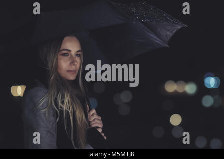 Fashion portrait de beaux gorgeous woman standing with parapluie sous la pluie pendant la nuit les lumières de la ville historique, la mélancolie concept Banque D'Images